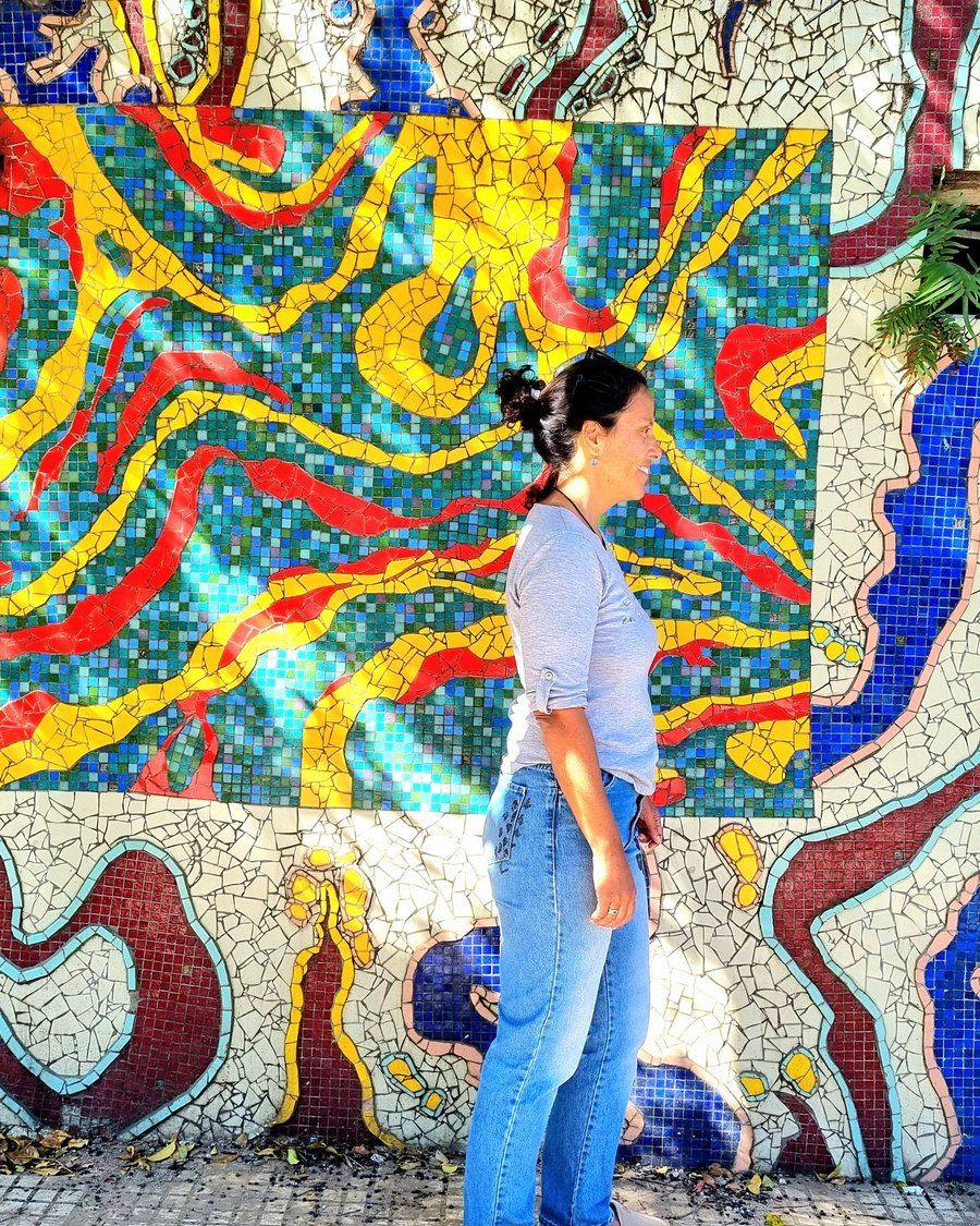 Mosaic mural by Marino Santa María on Pasaje Lanín, Barracas, with a visitor walking past
